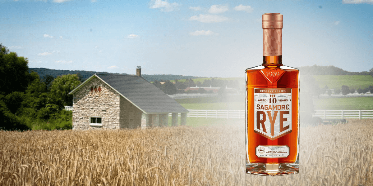 Bottle of Sagamore Spirit 10-Year Rye Whiskey standing in front of a Maryland rye field and stone house, highlighting its farm-to-glass heritage.