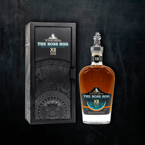 A bottle of WhistlePig The Boss Hog XII: Feather & Flame straight rye whiskey stands beside its black presentation box on a black background